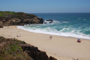 light teal waves wash up on a sandy shore at Montara