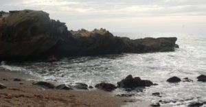 sun shines on a rough and rocky ocean shore