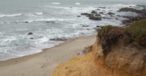 rocky cliff over rough gray ocean waters