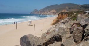 large rocks lead to a sandy beach