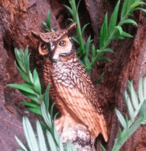 fake owl nestled in a tree hollow