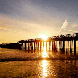 bright yellow sunset behind the seacliff pier