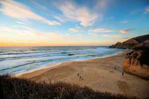 bright orange and yellow sunset over a sandy beach