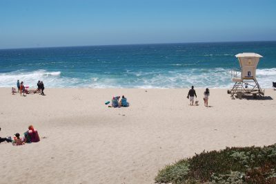 Ocean surf with beach visitors and a lifeguard tower