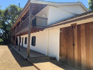front porch of the castro adobe with new wooden doors to a shed to the side