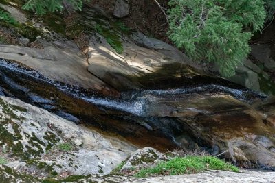 Small stream of water flows down a rockface