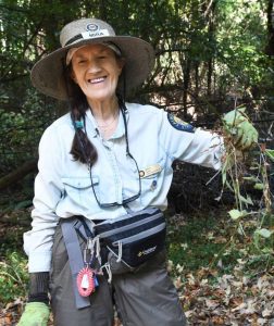 A State Parks volunteer holding up an invasive plant