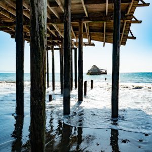 A view of the cement ship at Seacliff State Beach through the old broken pier